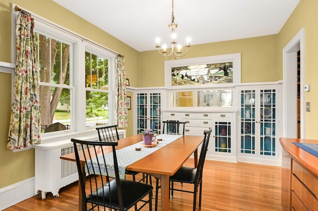 901 42nd St, Minneapolis, MN 55409 - dining room featuring radiator, wood finished floors, and a chandelier