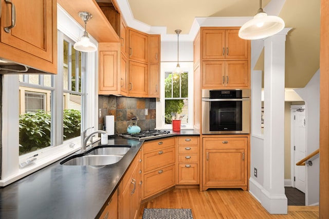 901 42nd St, Minneapolis, MN 55409 - kitchen with stainless steel appliances, light wood-type flooring, backsplash, and dark countertops