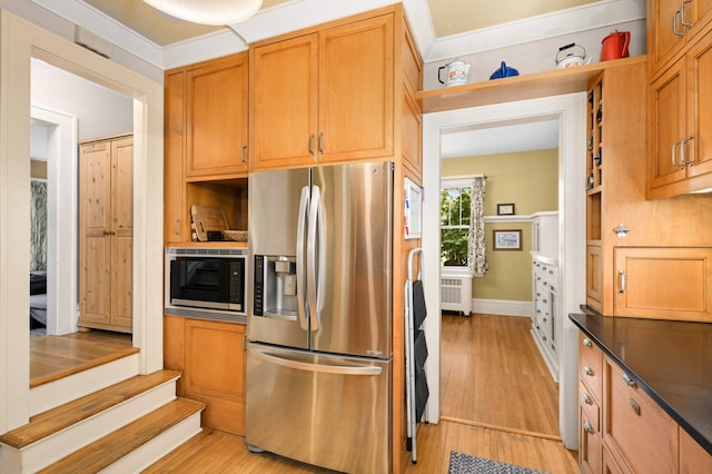 901 42nd St, Minneapolis, MN 55409 - kitchen with stainless steel appliances, radiator, light wood-style flooring, and dark countertops