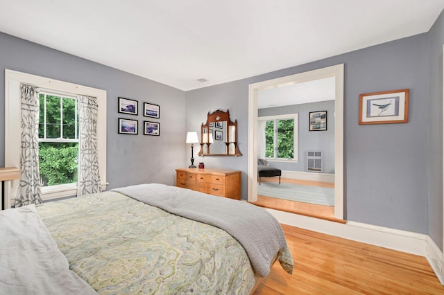 901 42nd St, Minneapolis, MN 55409 - bedroom with wood finished floors, multiple windows, and heating unit