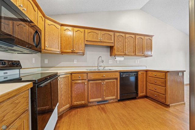 2812 Wheatland Dr S, Fargo, ND 58103 - kitchen featuring black appliances, vaulted ceiling, light wood-style flooring, and light countertops