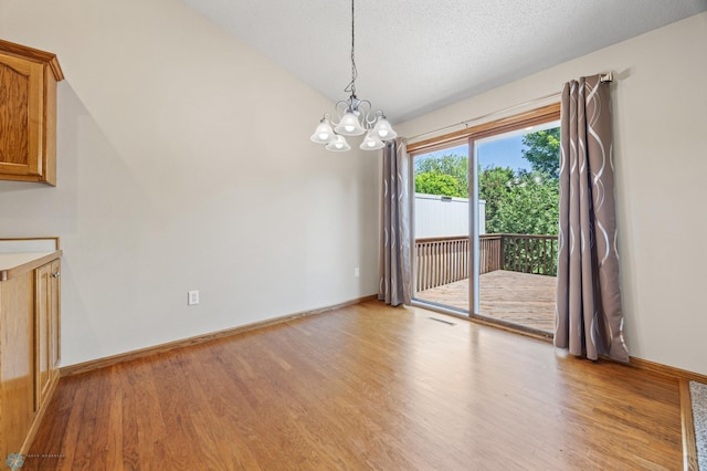 2812 Wheatland Dr S, Fargo, ND 58103 - unfurnished dining area with a chandelier, light wood-style floors, and vaulted ceiling