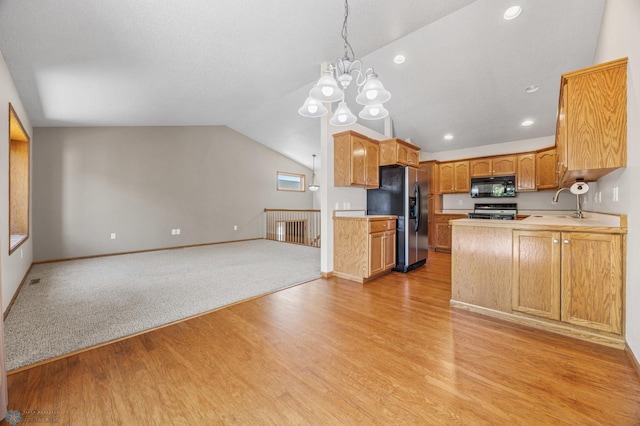 2812 Wheatland Dr S, Fargo, ND 58103 - kitchen featuring black appliances, open floor plan, light countertops, light wood finished floors, and vaulted ceiling
