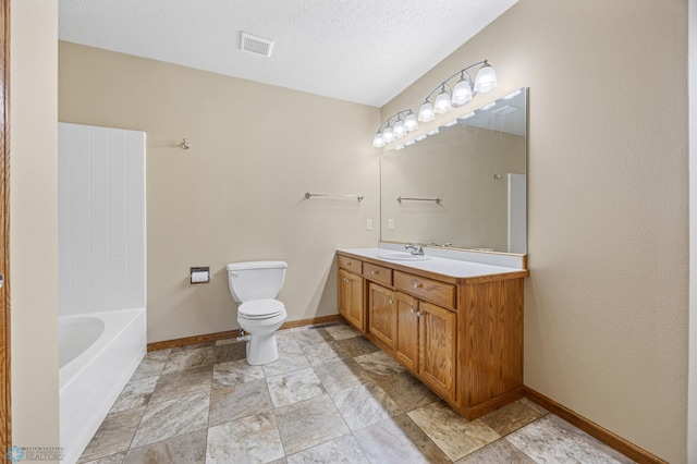 2812 Wheatland Dr S, Fargo, ND 58103 - bathroom with vanity, stone finish floors, and a textured ceiling
