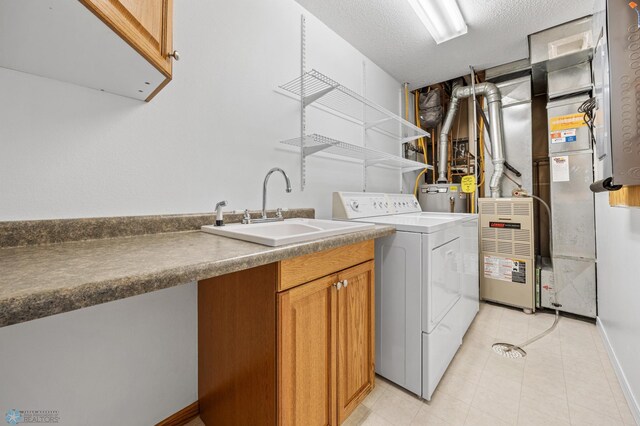 2812 Wheatland Dr S, Fargo, ND 58103 - washroom featuring cabinet space, light tile patterned flooring, washer and clothes dryer, a textured ceiling, and water heater