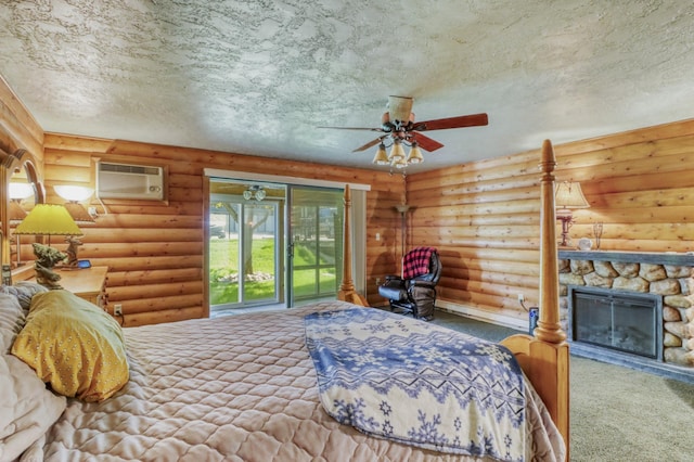 315 Park Lake Blvd Unit 104, Detroit Lakes, MN 56501 - bedroom with an AC wall unit, carpet, a textured ceiling, a stone fireplace, and access to outside