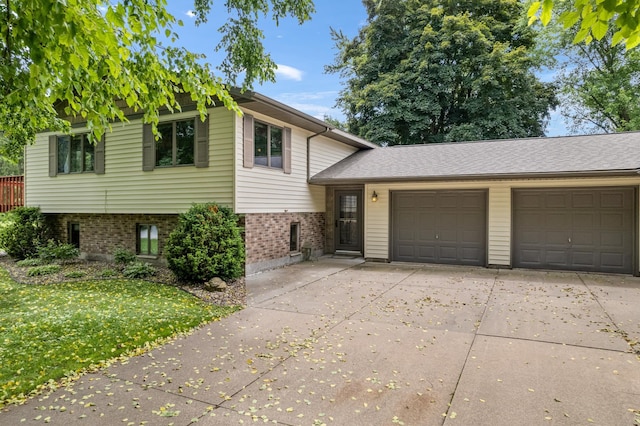39123 Kc Dr, Homer Twp, MN 55987 - split level home with driveway, brick siding, an attached garage, and a front yard