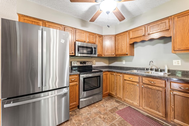 39123 Kc Dr, Homer Twp, MN 55987 - kitchen featuring stainless steel appliances, dark countertops, a ceiling fan, stone finish flooring, and a textured ceiling