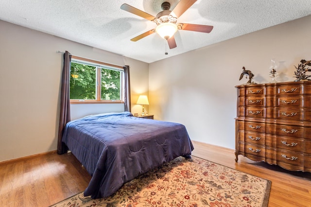 39123 Kc Dr, Homer Twp, MN 55987 - bedroom featuring wood finished floors, a textured ceiling, and a ceiling fan