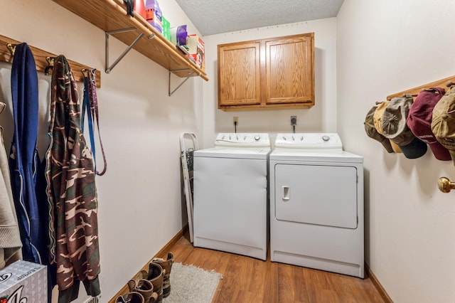 39123 Kc Dr, Homer Twp, MN 55987 - laundry room with independent washer and dryer, cabinet space, and light wood-style flooring