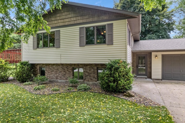 39123 Kc Dr, Homer Twp, MN 55987 - tri-level home featuring a garage, a front lawn, concrete driveway, and brick siding