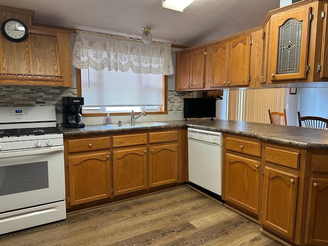 217 4th Ave SE, Pipestone, MN 56164 - kitchen featuring white appliances, dark countertops, brown cabinets, wood finished floors, and a textured ceiling