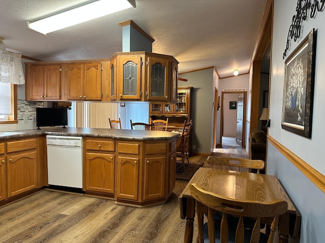 217 4th Ave SE, Pipestone, MN 56164 - kitchen featuring dishwasher, a textured ceiling, wood finished floors, brown cabinetry, and tasteful backsplash