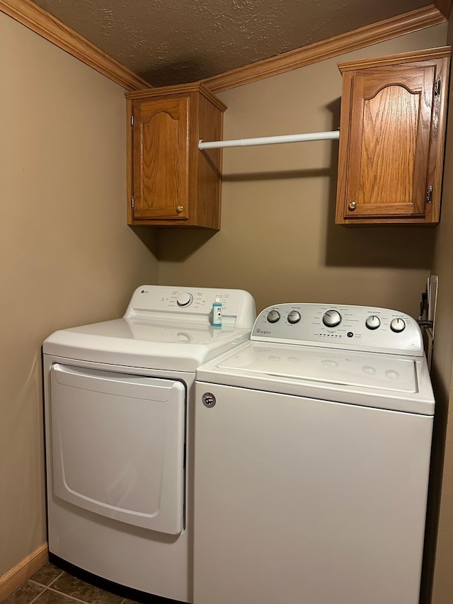 217 4th Ave SE, Pipestone, MN 56164 - laundry room featuring washing machine and clothes dryer, ornamental molding, cabinet space, a textured ceiling, and dark tile patterned flooring