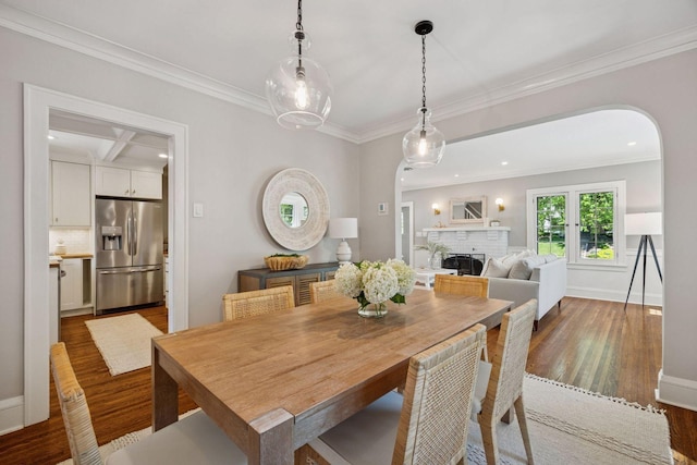 4510 Arden Ave, Edina, MN 55424 - dining space with arched walkways, wood finished floors, a brick fireplace, ornamental molding, and recessed lighting