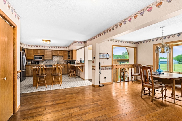 9614 Hayes Rd, Mountain Iron, MN 55768 - dining room featuring a textured ceiling, wood-type flooring, and a chandelier