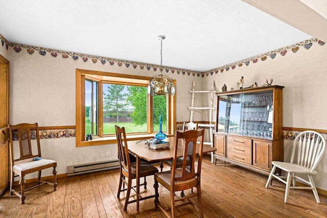 9614 Hayes Rd, Mountain Iron, MN 55768 - dining room featuring baseboard heating, a chandelier, and hardwood / wood-style floors