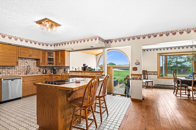 9614 Hayes Rd, Mountain Iron, MN 55768 - kitchen with dishwasher, tile counters, plenty of natural light, a kitchen bar, and a textured ceiling