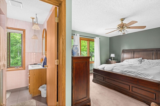 9614 Hayes Rd, Mountain Iron, MN 55768 - bedroom featuring a textured ceiling, tile walls, light tile patterned flooring, arched walkways, and ceiling fan