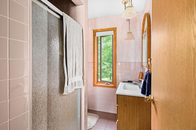 9614 Hayes Rd, Mountain Iron, MN 55768 - bathroom featuring tile walls, vanity, a stall shower, and tile patterned flooring