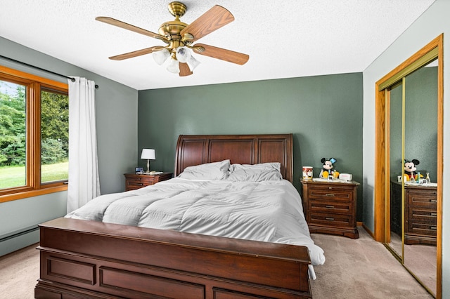 9614 Hayes Rd, Mountain Iron, MN 55768 - bedroom with light carpet, a closet, ceiling fan, a textured ceiling, and a baseboard heating unit
