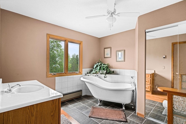 9614 Hayes Rd, Mountain Iron, MN 55768 - bathroom featuring a baseboard radiator, vanity, a soaking tub, tile patterned flooring, and a ceiling fan