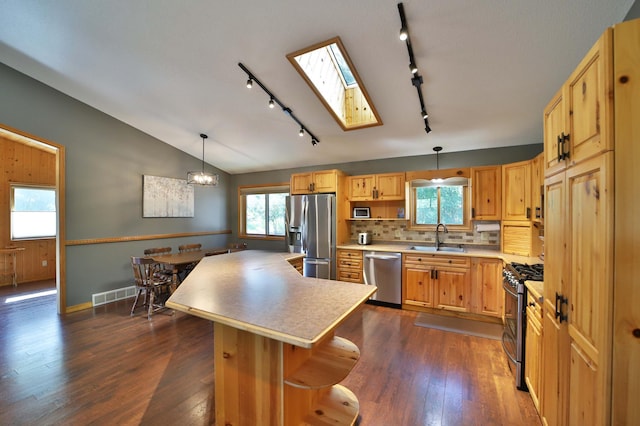 30467 Lakeview Dr, Breezy Point, MN 56472 - kitchen featuring appliances with stainless steel finishes, a skylight, light countertops, a center island, and lofted ceiling