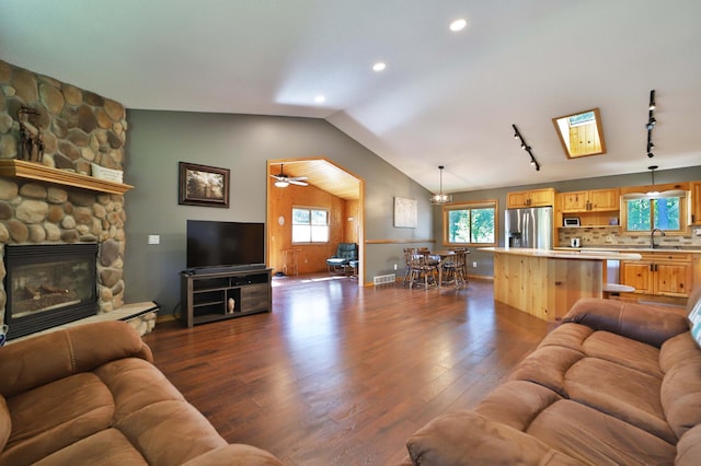 30467 Lakeview Dr, Breezy Point, MN 56472 - living area featuring dark wood finished floors, vaulted ceiling, recessed lighting, a fireplace, and rail lighting