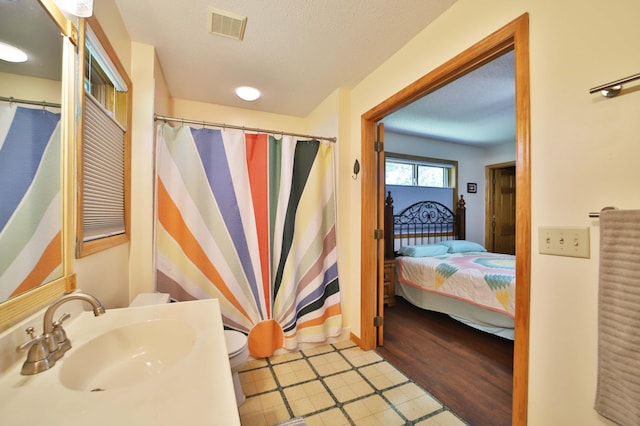 30467 Lakeview Dr, Breezy Point, MN 56472 - ensuite bathroom with a shower with shower curtain, a textured ceiling, vanity, and tile patterned floors