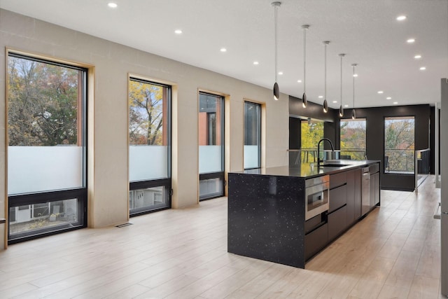 3318 Owasso Blvd, Shoreview, MN 55126 - kitchen with modern cabinets, a large island, recessed lighting, stainless steel microwave, and decorative light fixtures