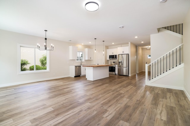 2529 Elmcroft Dr SW, Rochester, MN 55902 - unfurnished living room featuring a chandelier, light wood finished floors, stairs, and recessed lighting