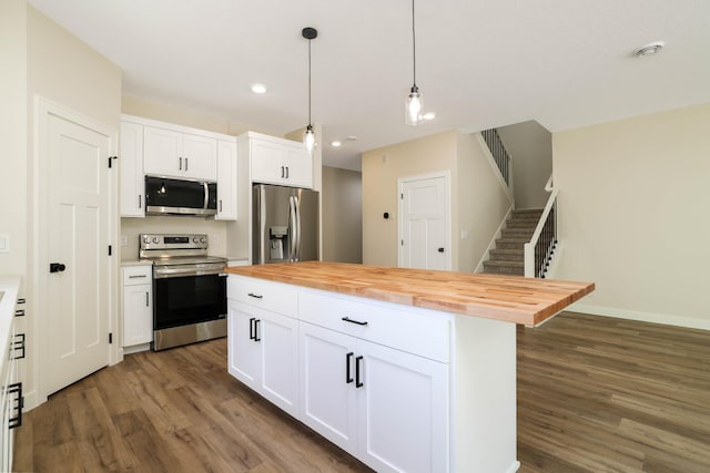 2529 Elmcroft Dr SW, Rochester, MN 55902 - kitchen with stainless steel appliances, butcher block countertops, wood finished floors, white cabinetry, and hanging light fixtures