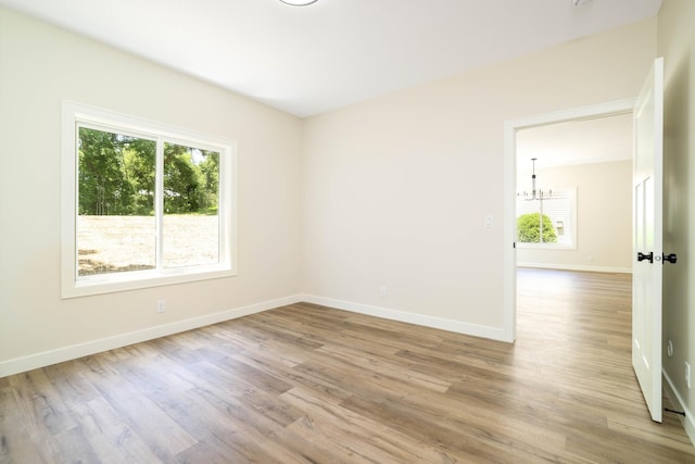 2529 Elmcroft Dr SW, Rochester, MN 55902 - spare room with plenty of natural light, a chandelier, and wood finished floors