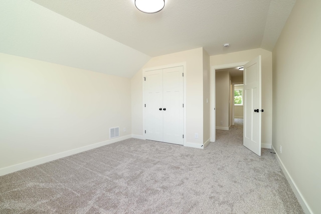 2529 Elmcroft Dr SW, Rochester, MN 55902 - unfurnished bedroom featuring carpet flooring, a closet, and vaulted ceiling