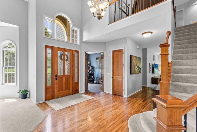 12346 Harvard Ave, Eden Prairie, MN 55347 - entryway with stairs, a towering ceiling, wood finished floors, and a chandelier