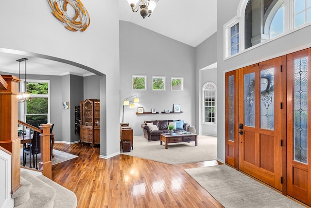 12346 Harvard Ave, Eden Prairie, MN 55347 - entryway with arched walkways, high vaulted ceiling, a chandelier, light wood-type flooring, and stairway