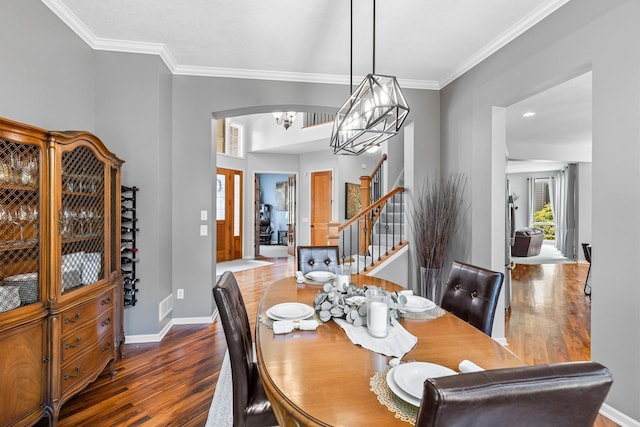 12346 Harvard Ave, Eden Prairie, MN 55347 - dining area with wood finished floors, arched walkways, stairs, ornamental molding, and a chandelier