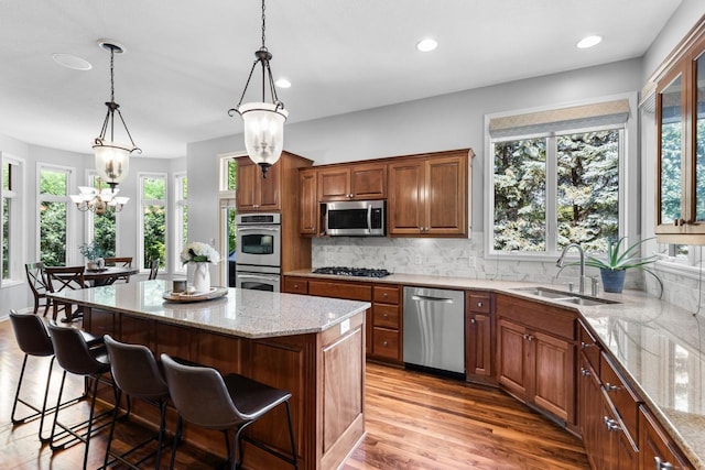 12346 Harvard Ave, Eden Prairie, MN 55347 - kitchen featuring appliances with stainless steel finishes, light stone counters, plenty of natural light, a chandelier, and recessed lighting