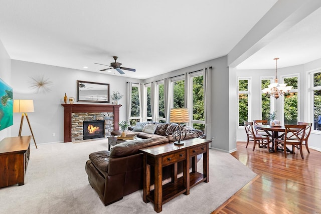 12346 Harvard Ave, Eden Prairie, MN 55347 - living area with a fireplace, a ceiling fan, a chandelier, and light wood-type flooring