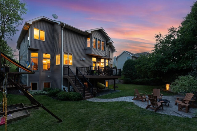 12346 Harvard Ave, Eden Prairie, MN 55347 - back of house at dusk featuring stairs, a patio area, a deck, an outdoor fire pit, and a lawn