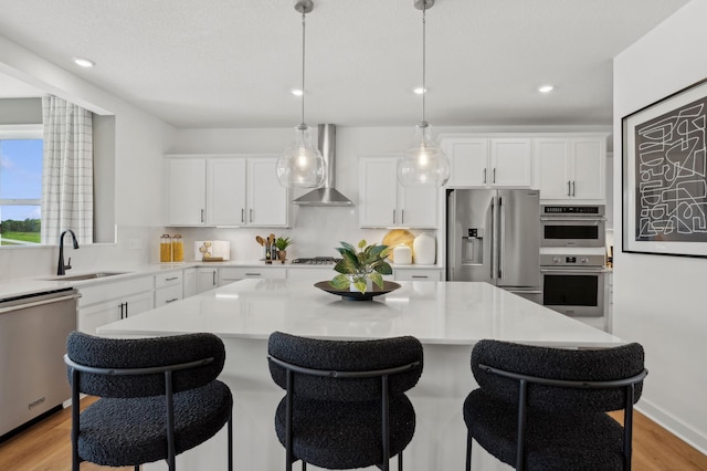 2548 Aspen Ct, Shakopee, MN 55379 - kitchen with stainless steel appliances, wall chimney range hood, a kitchen island, a kitchen bar, and white cabinets