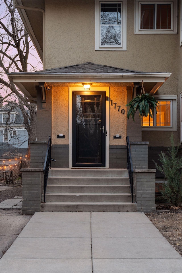 1770 Humboldt Ave S Unit 1, Minneapolis, MN 55403 - doorway to property featuring stucco siding, a porch, and brick siding