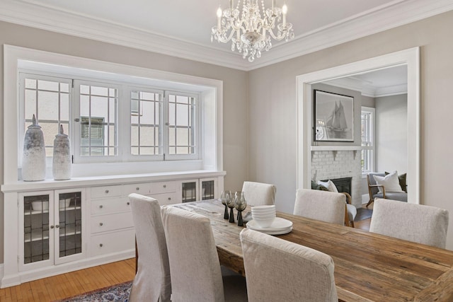 1770 Humboldt Ave S Unit 1, Minneapolis, MN 55403 - dining room featuring crown molding, a chandelier, a brick fireplace, and light wood finished floors