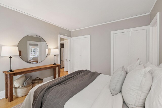 1770 Humboldt Ave S Unit 1, Minneapolis, MN 55403 - bedroom featuring light wood-style floors, crown molding, and multiple closets