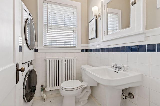 1770 Humboldt Ave S Unit 1, Minneapolis, MN 55403 - bathroom featuring radiator, stacked washer / dryer, tile walls, and wainscoting