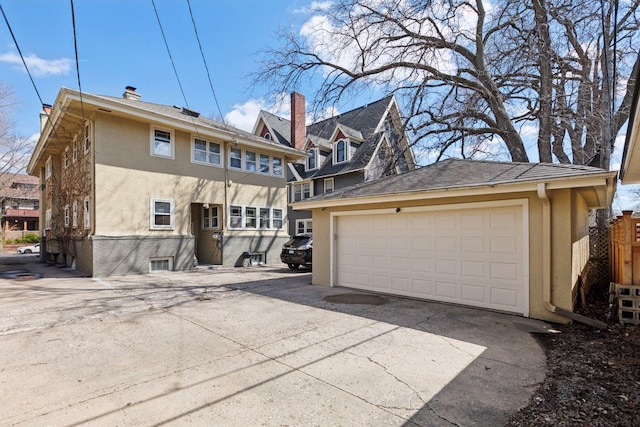 1770 Humboldt Ave S Unit 1, Minneapolis, MN 55403 - back of house featuring stucco siding, a detached garage, and an outdoor structure