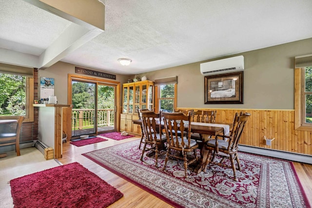 4745 Patterson Trl, Brainerd, MN 56401 - dining area featuring a wall unit AC, a textured ceiling, plenty of natural light, a wainscoted wall, and wood finished floors