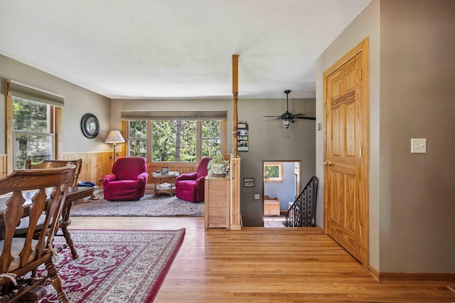 4745 Patterson Trl, Brainerd, MN 56401 - living room with healthy amount of natural light, light wood-type flooring, wainscoting, and ceiling fan