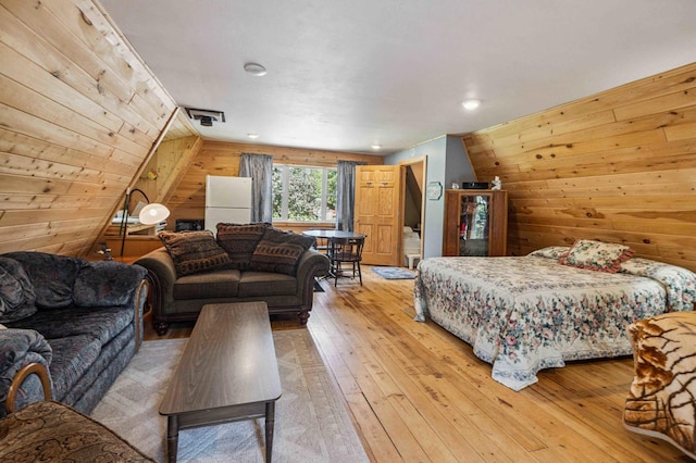 4745 Patterson Trl, Brainerd, MN 56401 - bedroom with wood walls, freestanding refrigerator, and light wood-style flooring