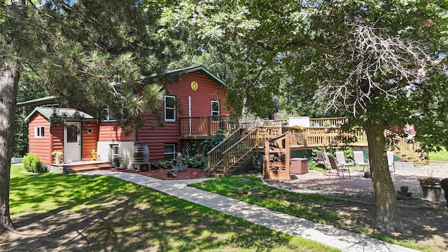 4745 Patterson Trl, Brainerd, MN 56401 - rear view of property featuring a deck, a yard, stairs, faux log siding, and a patio area